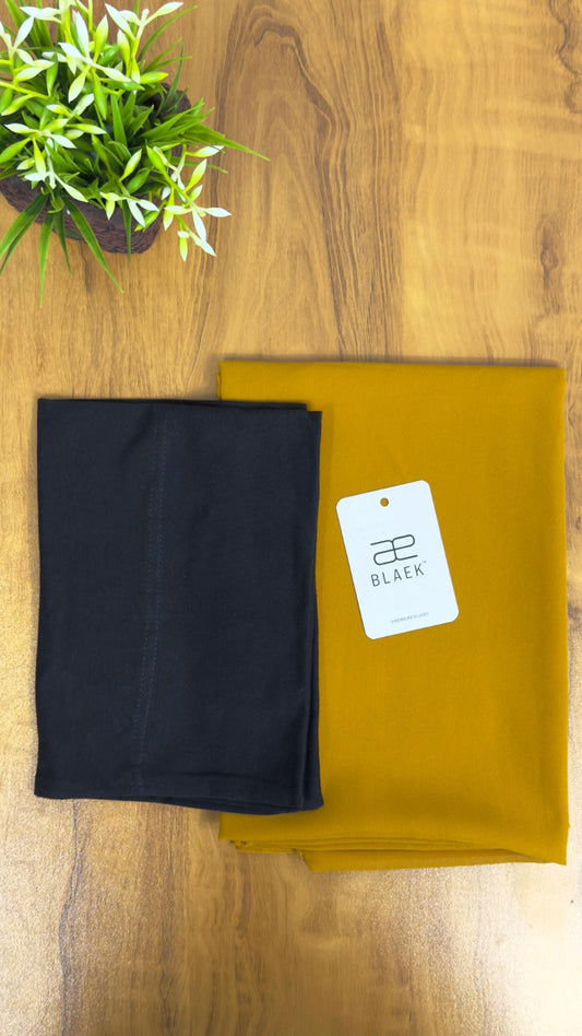 Vibrant mustard hijab paired with a sleek black cap for a bold contrast.