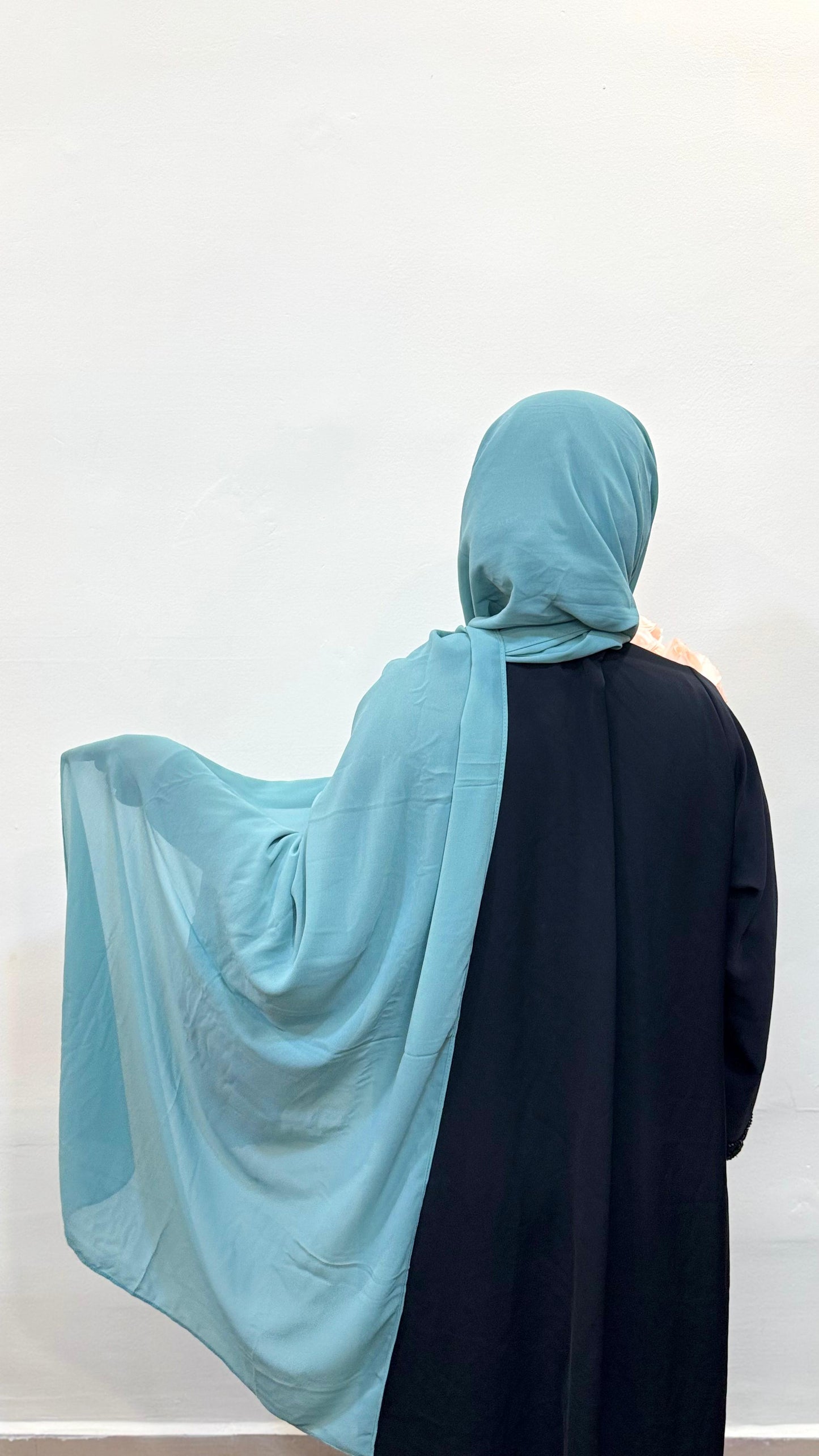 Mint green hijab with a cool cyan undertone, giving a fresh, airy, and modern vibe.