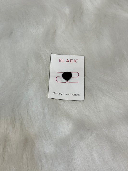 Premium heart-shaped hijab magnet in black, elegantly packaged and set against a modern backdrop.