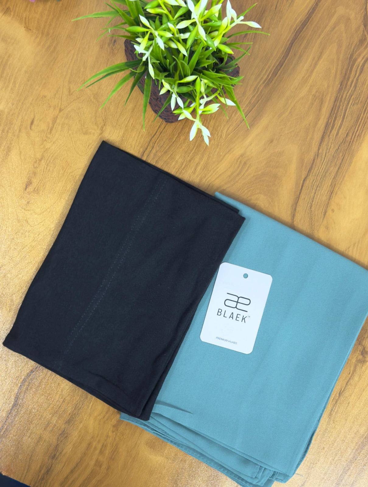 Cool-toned mint hijab with a sharp black cap for effortless style.