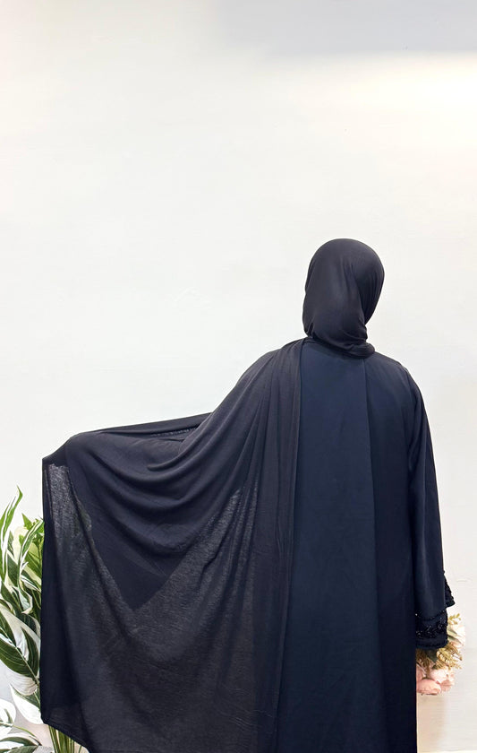 Elegant black jersey hijab with soft, flowing drapes for a sleek and modest look.
