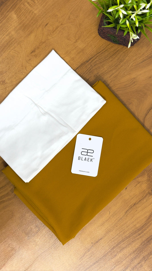 Crisp white cap and mustard slider hijab folded flat.